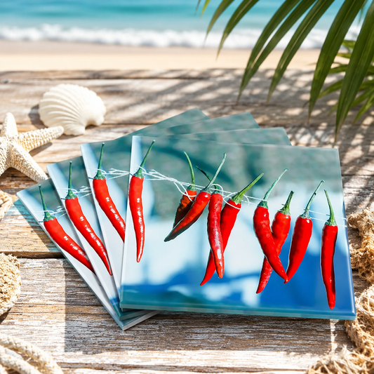 Stack of ceramic coasters with red chili peppers design on a beach setting